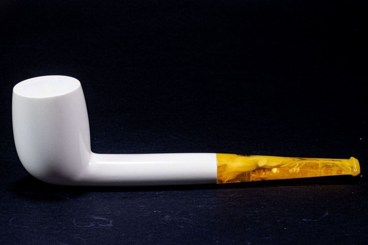 Polished Meerschaum Liverpool pipe with a straight white bowl and a translucent amber stem, set against a dark background